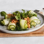 Delicious zucchini and lentil salad garnished with herbs on a wooden board, perfect for healthy eating.